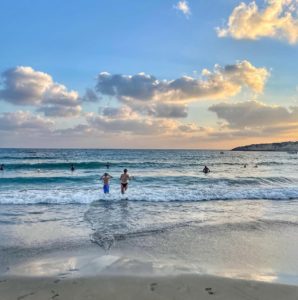 Image of people running into the sea